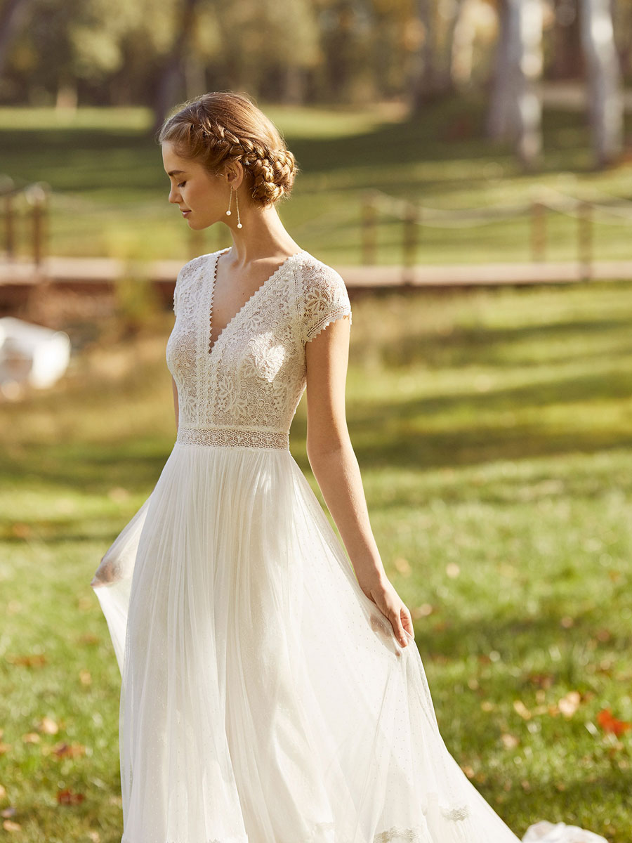 Elegant bridal gown with V-neckline and drop sleeves.