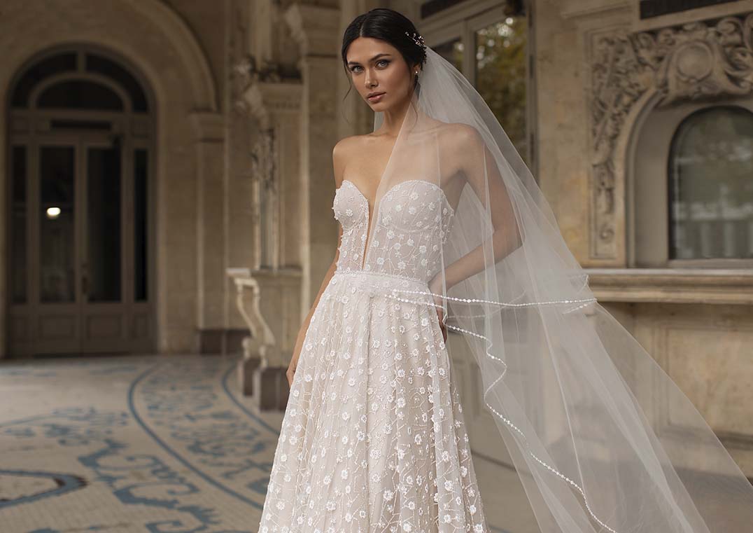 soft and summery field-of- flowers embroidered tulle and features a strapless sweetheart neckline and a court train.