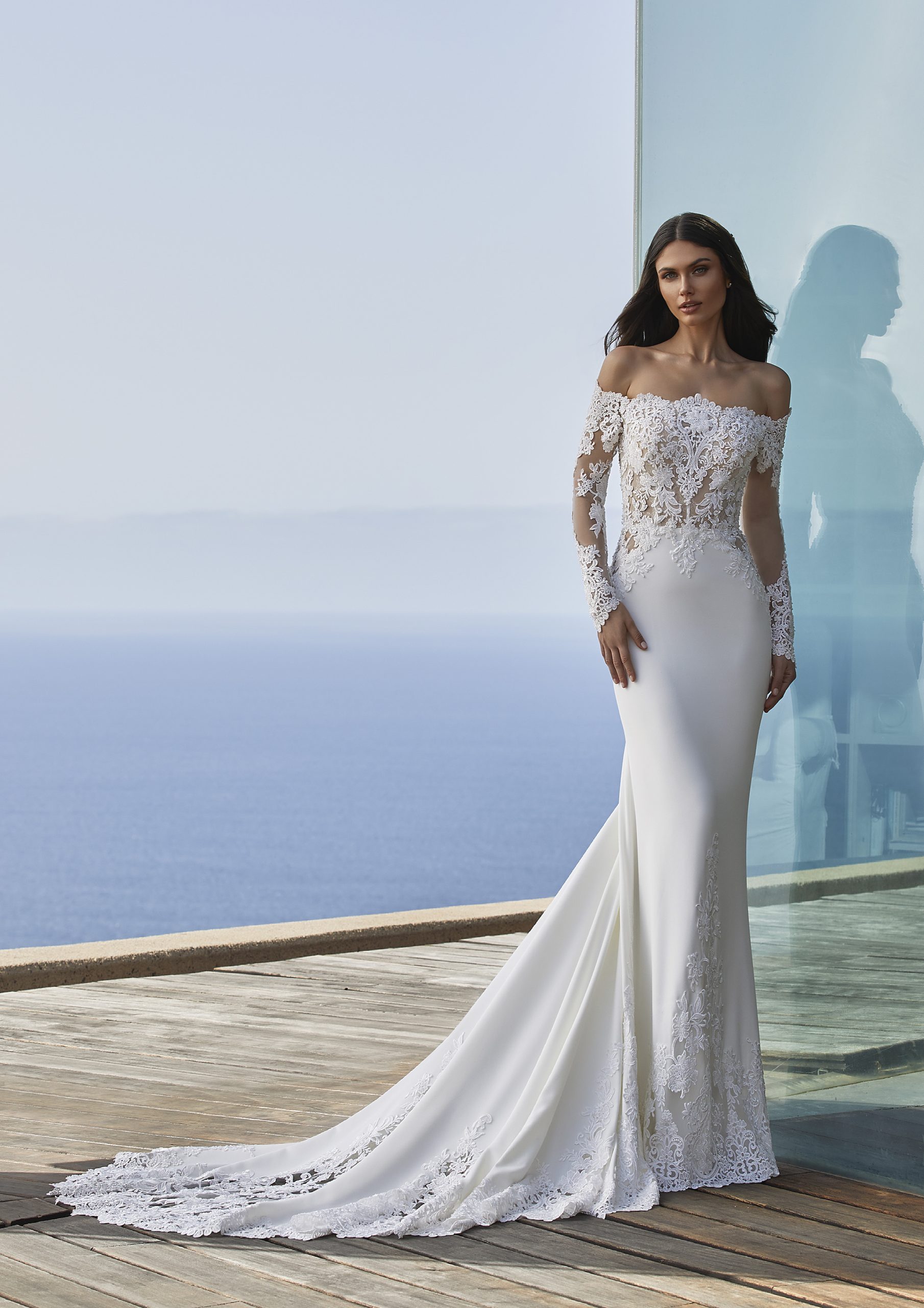 Off-the-shoulder seduction and heavenly lace inserts combine in this spectacular mermaid-style gown crafted in crepe