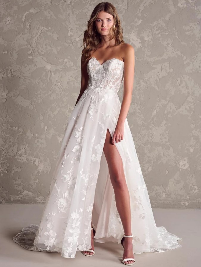 TheRomantic A-line gown features floral appliqués and lace with a sweetheart neckline and optional off-the-shoulder or long lace sleeves.